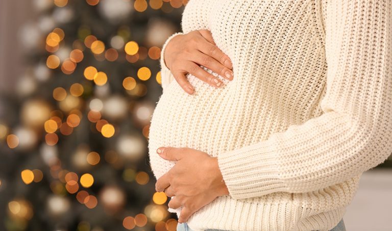 A pregnant woman caressing her unborn baby on a festival occasion