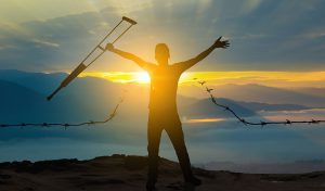 A recovered energetic male happily throwing away his crutch