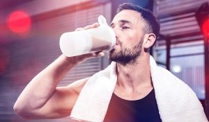 A young male having a nutrition drink containing triple protein blend post work out