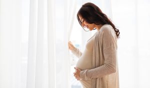 A pregnant woman caressing her unborn baby